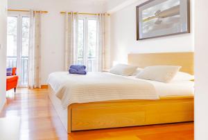 um quarto com uma cama grande e um urso de peluche. em Harmony Apartment no Funchal