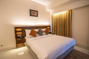 um quarto com uma cama grande e uma janela em Jatra Flagship Khulna City Centre em Khulna
