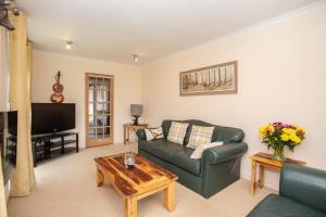 ein Wohnzimmer mit einem grünen Sofa und einem Couchtisch in der Unterkunft Aftonbank in Pitlochry