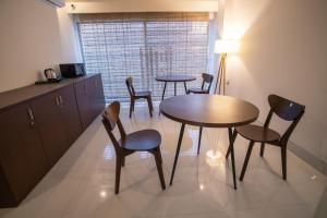 una cucina con due tavoli e sedie in una stanza di Jatra Flagship Khulna City Centre a Khulna