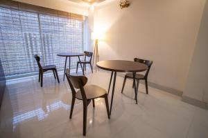 - un groupe de tables et de chaises dans une chambre avec fenêtre dans l'établissement Jatra Flagship Khulna City Centre, à Khulna