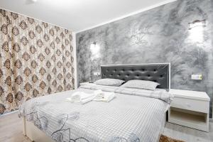 a bedroom with a bed with white sheets and a wall at Cazare Moldi Btt in Câmpulung Moldovenesc