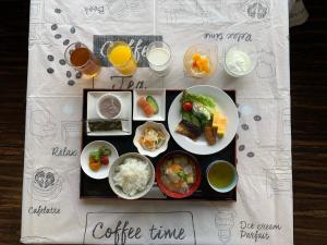 una mesa con platos de comida y vasos de zumo de naranja en Green Rich Hotel Kagoshima Tenmonkan, en Kagoshima
