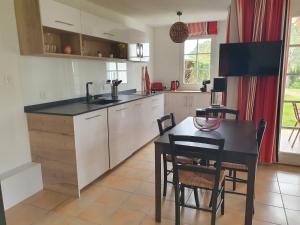 a kitchen with a table and a dining room at appartement domaine de Bordaberry Urrugne in Urrugne