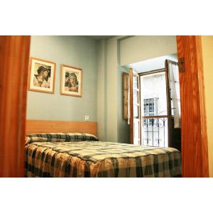 1 dormitorio con cama, ventana y espejo en La Refierta, en Cangas del Narcea