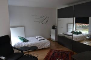 1 dormitorio con 2 camas, silla y espejo en Casa Tilleghem, en Brujas