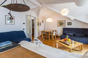 Una sala de estar con un sofá azul y una mesa. en Attico Vista Lago, en Como