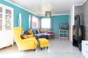 ein Wohnzimmer mit einem Sofa und einem gelben Stuhl in der Unterkunft Kleine Strandpiraten in Grömitz