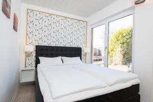 ein Schlafzimmer mit einem großen weißen Bett und einem Fenster in der Unterkunft Kleine Strandpiraten in Grömitz