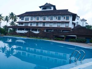 un hotel con piscina frente a un edificio en The Leela Ashtamudi, A Raviz Hotel, en Kollam