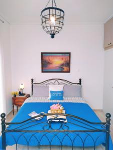 um quarto com uma cama azul e um cobertor azul em Emily`s vacation house em Kalívia Thorikoú