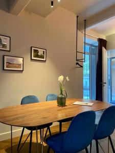 a dining room with a wooden table and blue chairs at VILLA ANNA Suite in Turin
