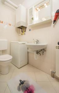 Baño blanco con lavabo y aseo en City Centre Sea View Apartment, en Pula