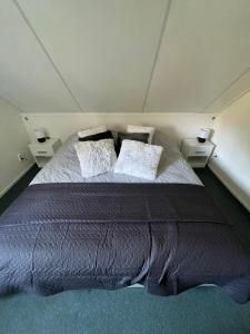 a bedroom with a large bed with two night stands at 't Holten Huus - Puur genieten in het bos. in Norg