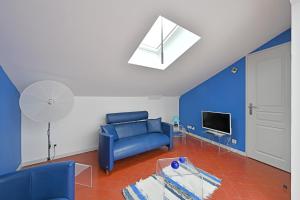 a living room with a blue couch and a tv at Place Carnot 1900: Coeur de Ville in Avignon