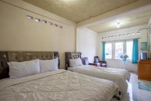 Postel nebo postele na pokoji v ubytování Hotel Jogja Bukittinggi