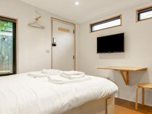 a bedroom with a bed with a tv on the wall at Pass the Keys Whitstable Tiny house - a secret getaway! in Whitstable