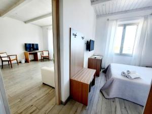 a white room with a bed and a window at La Promenade Rooms & Suites in Olbia