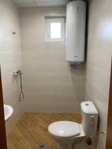 een badkamer met een toilet, een wastafel en een raam bij Apartment Kiril and Metodi 41-8А in Berkovitsa