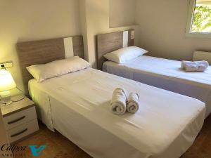 um quarto com 2 camas e toalhas em Oasis 1A Playa Arenal Calpe em Calpe