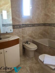 ein Badezimmer mit einem Waschbecken, einem WC und einer Badewanne in der Unterkunft Oasis 1A Playa Arenal Calpe in Calpe