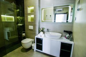 uma casa de banho com um lavatório, um WC e um espelho. em Apartmani Hiza i Vila em Betina
