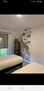 1 Schlafzimmer mit 2 Betten und einem Wandbild von Giraffen in der Unterkunft Belle vue D'Olhain in Fresnicourt-le-Dolmen