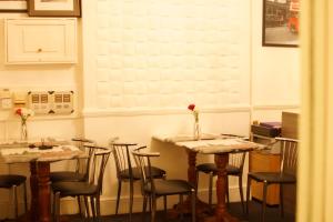 uma sala de jantar com mesas e cadeiras com flores em Plaza Hotel em Londres