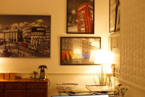 een kamer met een tafel en een lamp en foto's aan de muur bij Plaza Hotel in Londen