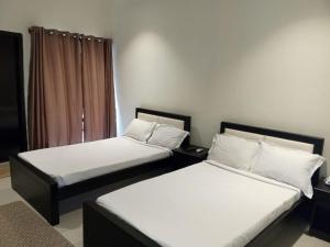 two beds sitting next to each other in a room at Marina Beach Villas Resort in Cox's Bazar
