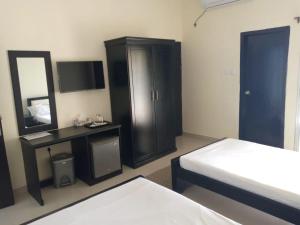 a bedroom with two beds and a dresser and a mirror at Marina Beach Villas Resort in Cox's Bazar +1 photo