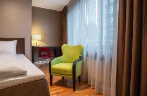 a room with a bed, chair and a lamp at Thon Hotel Slottsparken in Oslo