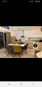 a kitchen and living room with a table and chairs at La Cooconing in Fresnicourt-le-Dolmen
