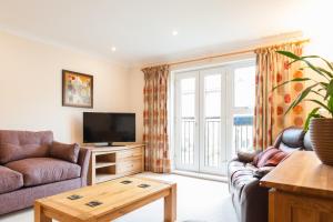 a living room with a couch and a tv at Camstay Longworth Avenue in Cambridge