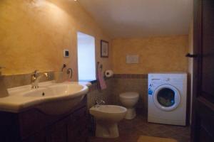 a bathroom with a sink and a washing machine at La Casa Del Viandante in Radicofani