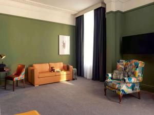 a living room with a couch and a chair at Mercure Bristol Grand Hotel in Bristol