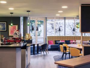 a restaurant with tables and chairs and a couch at Mercure Stuttgart Zuffenhausen in Stuttgart