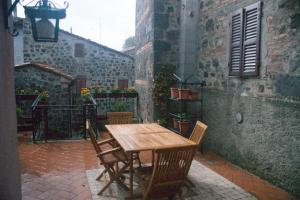 a wooden table and chairs on a patio at La Casa Del Viandante in Radicofani