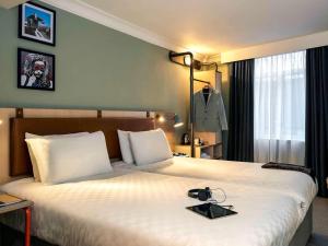 
a hotel room with a bed and a lamp at Mercure Bristol Grand Hotel in Bristol
