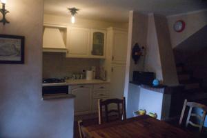a kitchen with white cabinets and a table and chairs at La Casa Del Viandante in Radicofani +4 photos