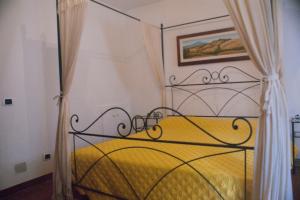 a bedroom with a yellow bed with a metal canopy at La Casa Del Viandante in Radicofani