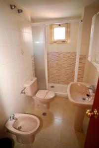 a bathroom with a toilet and a sink at Apartamentos Torre Gerona in Benidorm