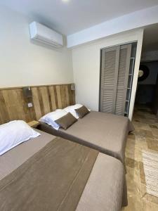 two beds in a hotel room with at L'Arche de Porquerolles in Porquerolles