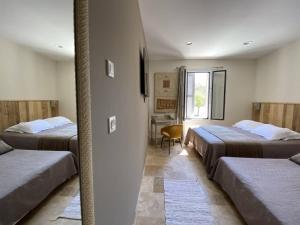a room with three beds and a chair in it at L'Arche de Porquerolles in Porquerolles