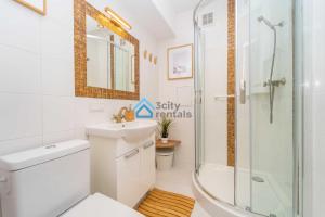 a bathroom with a shower and a toilet and a sink at Navy Blue Superior Apartment in Gdynia