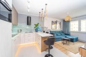a kitchen and living room with a blue couch at Navy Blue Superior Apartment in Gdynia