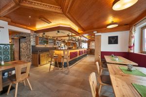 un restaurante con techos de madera, mesas y sillas de madera en Hotel Langeck en Maria Alm am Steinernen Meer