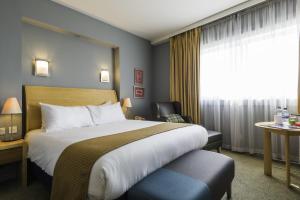 a hotel room with a bed and a window at Best Western London Heathrow Ariel Hotel in Hillingdon