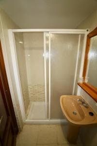 y baño con ducha y lavamanos. en Apartamentos Mariscal VII, en Benidorm