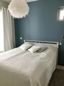 a bedroom with a white bed and a blue wall at Seastar 101 in Kalajoki